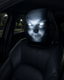 A black car headliner mask with glowing white eyes, shown fitted over a car seat at night.